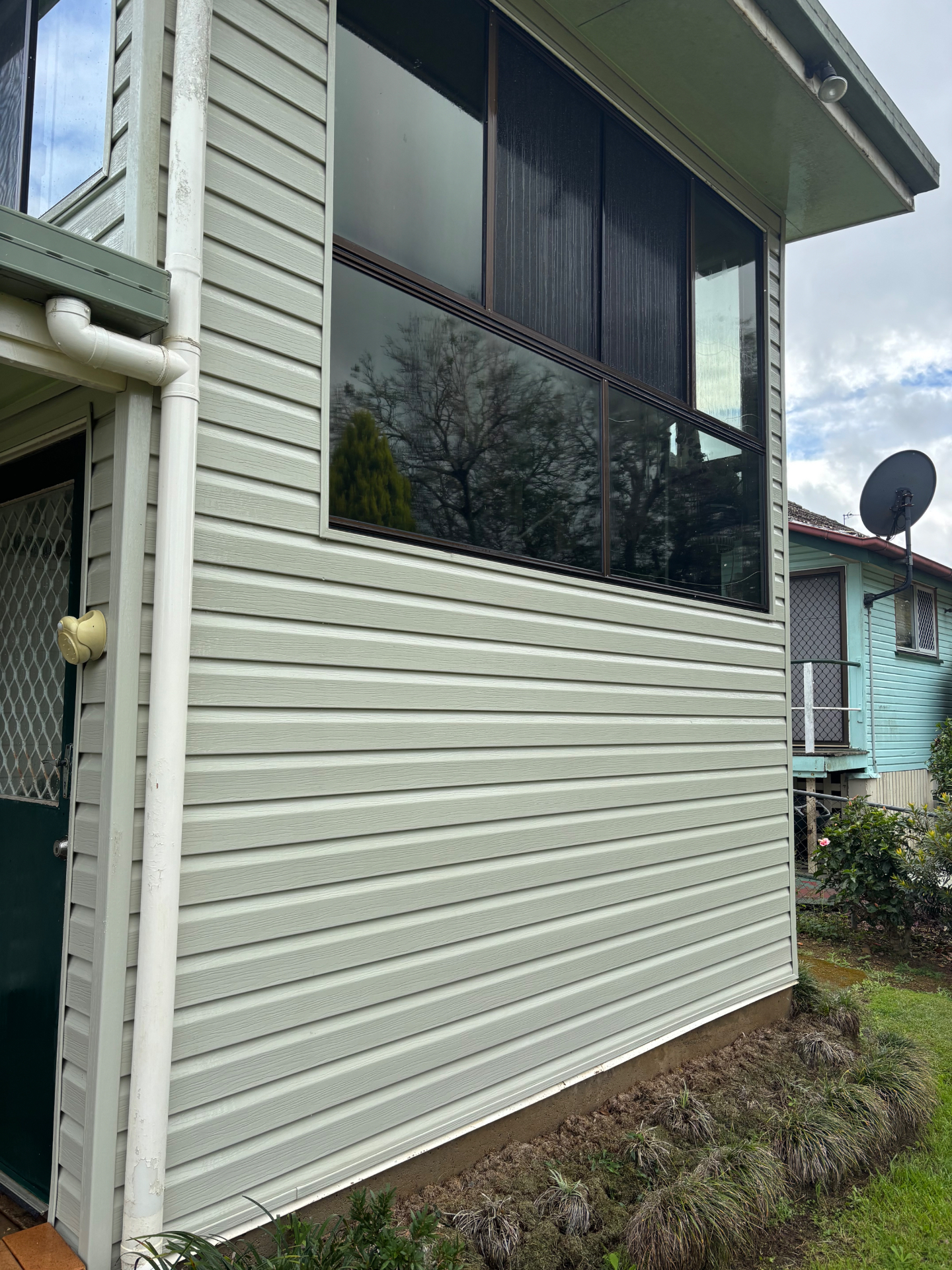 Mould and grime soft washed off weatherboard cladding. — after